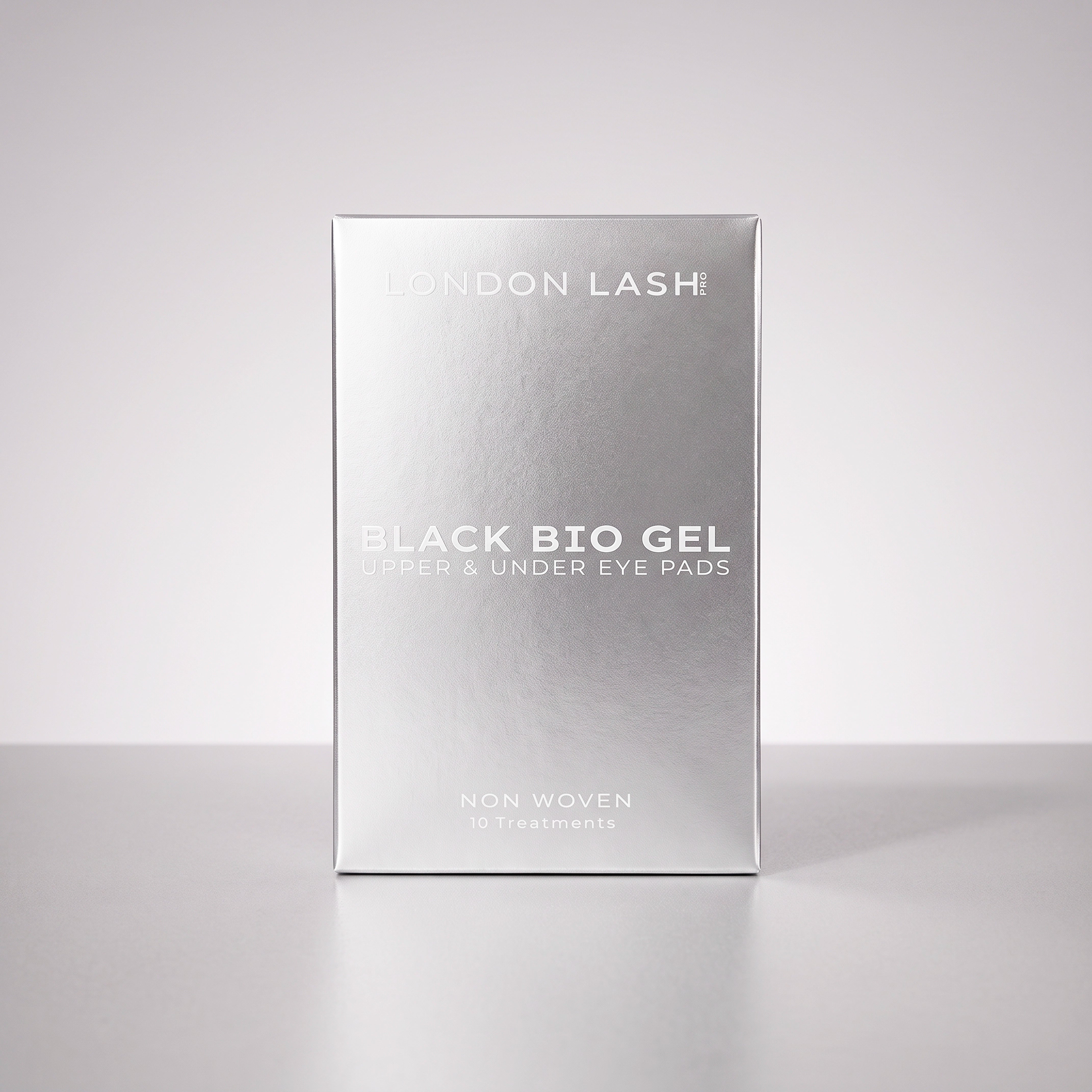 A silver rectangular box of London Lash Black Bio Gel upper and under eye pads, standing upright on a light gray surface against a light gray background.