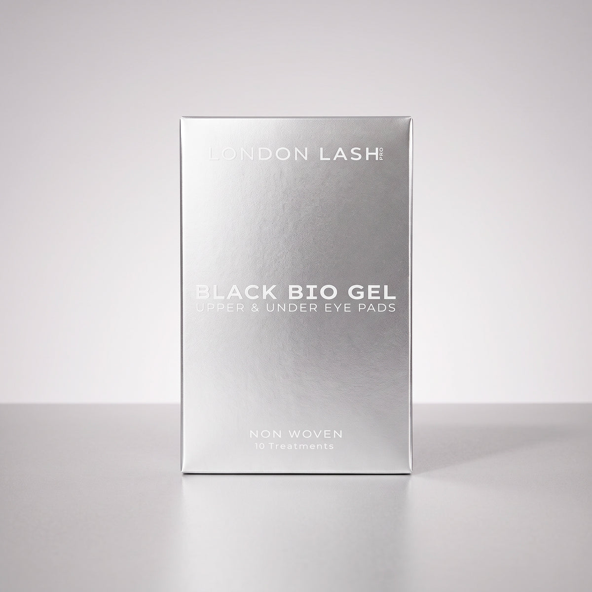 A silver rectangular box of London Lash Black Bio Gel upper and under eye pads, standing upright on a light gray surface against a light gray background.
