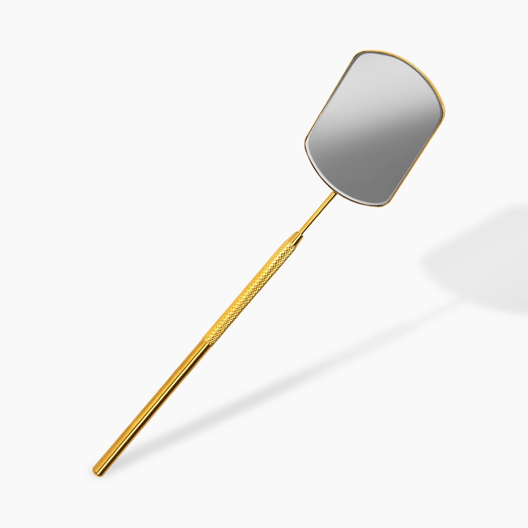 Gold lash mirror with a reflective gray paddle on a white background