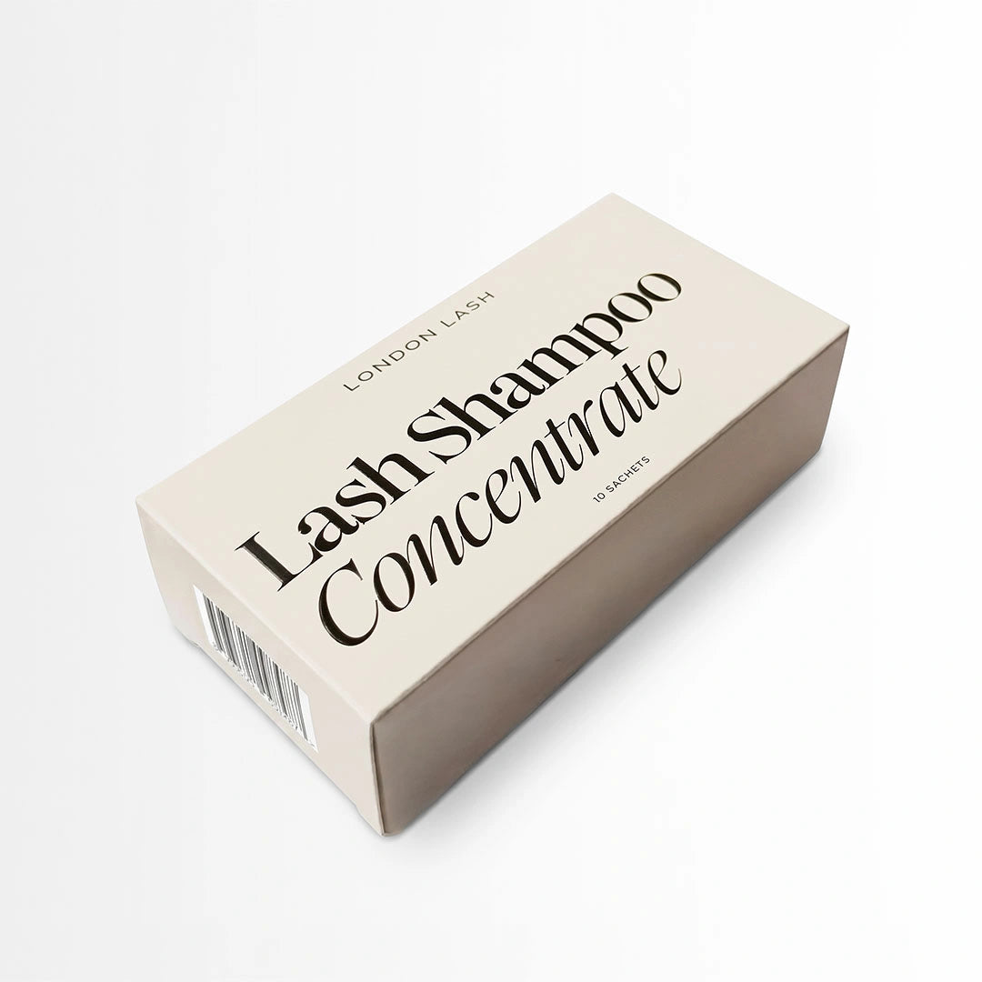 A rectangular beige box of London Lash Lash Shampoo Concentrate, photographed at an angle on a clean white background.