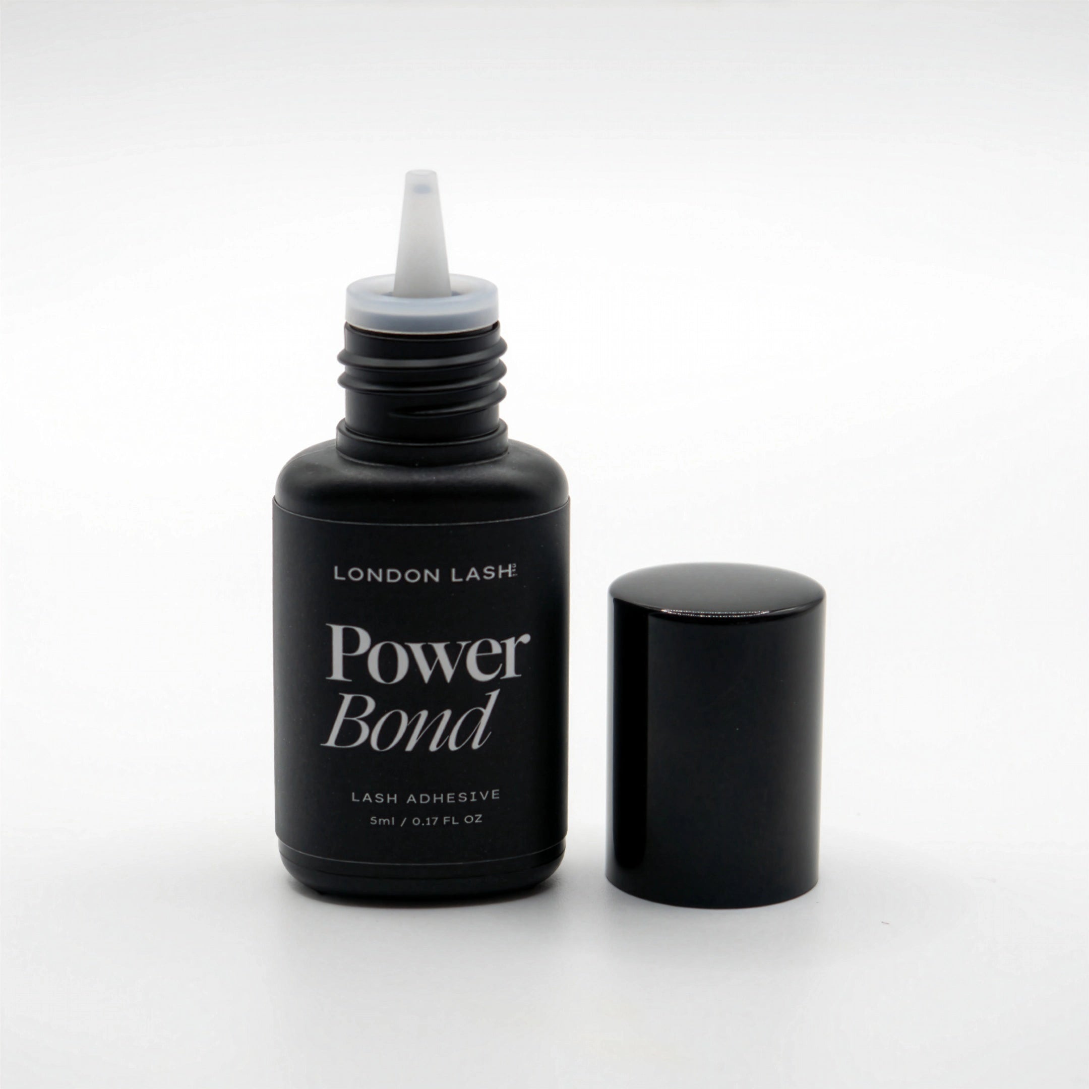 Opened bottle of London Lash Power Bond lash adhesive on a white background