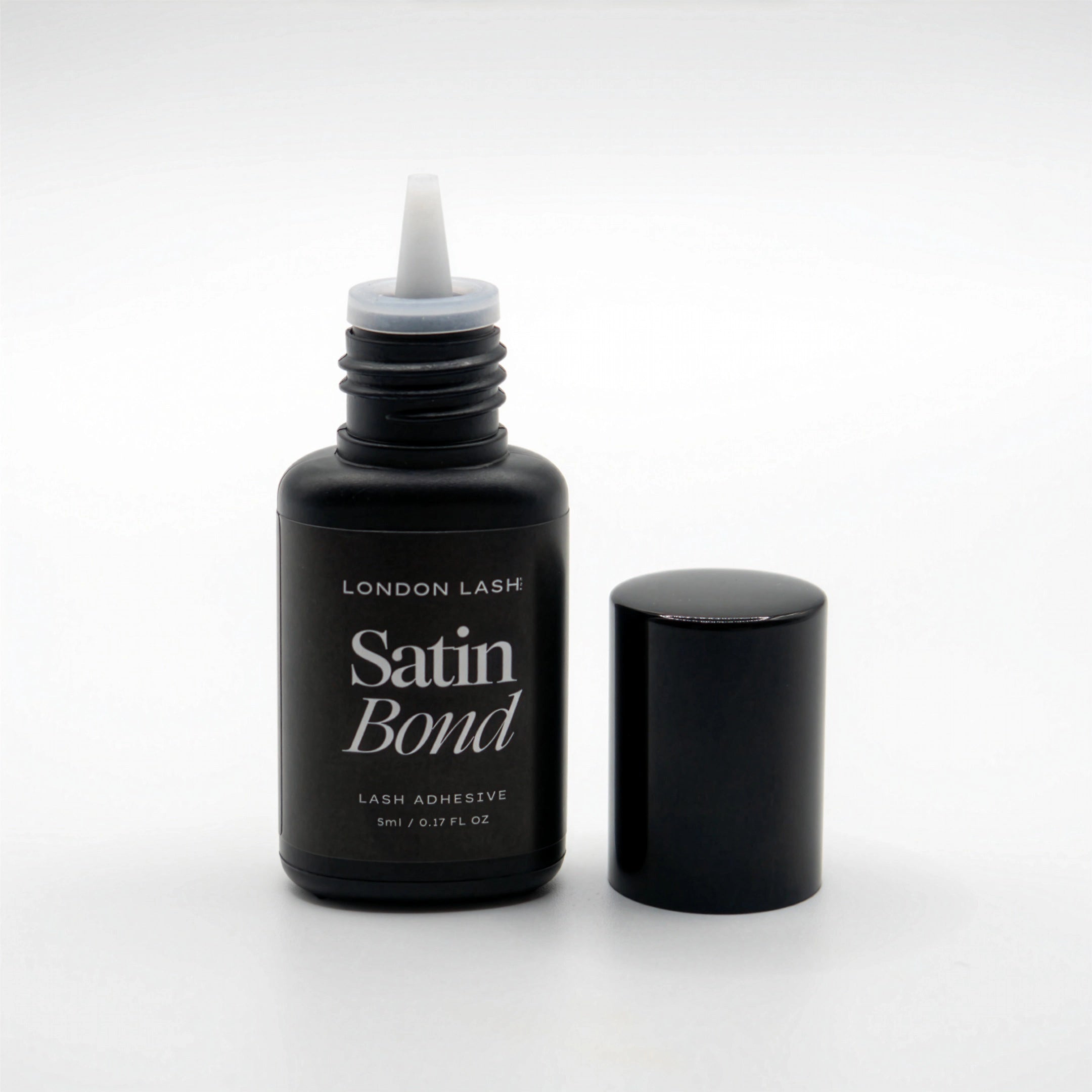 Opened bottle of London Lash Satin Bond lash adhesive on a white background