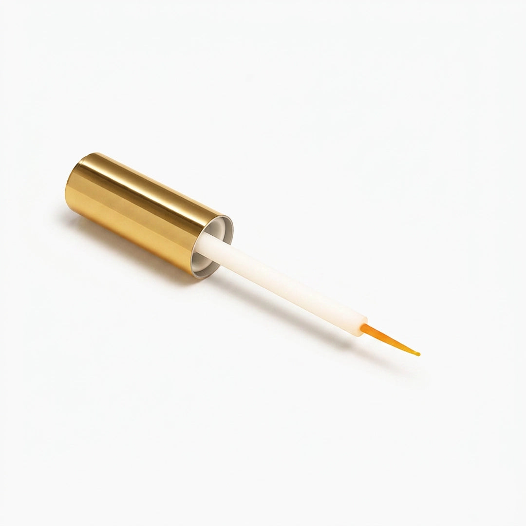 Gold cylindrical container with a white and orange applicator on a white background